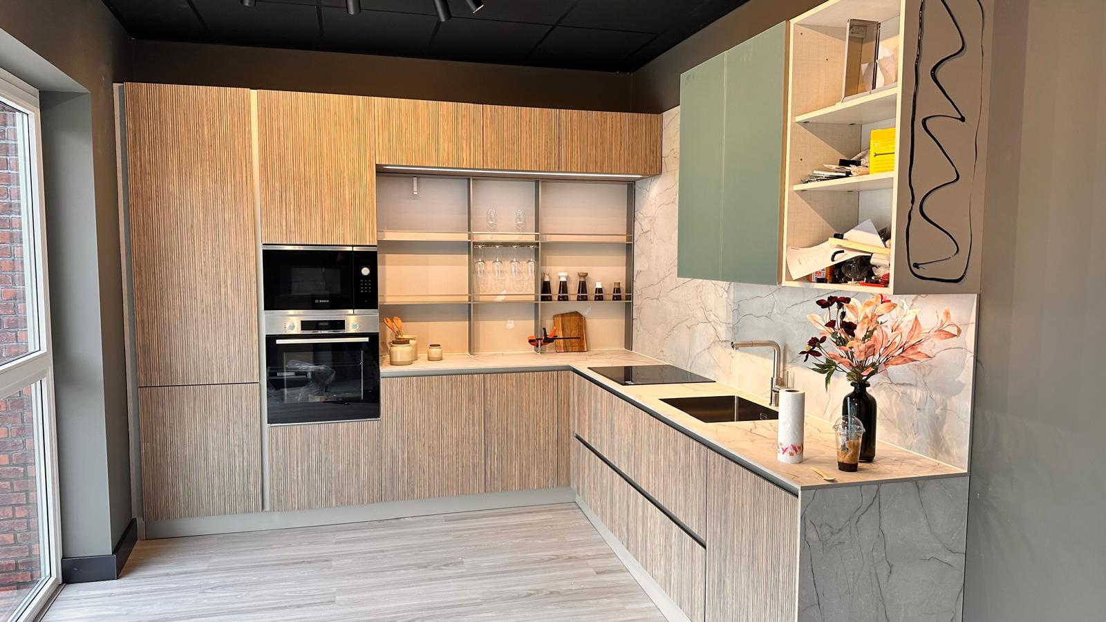 Moderne keuken met houten fronten, groene bovenkasten en marmerlook blad