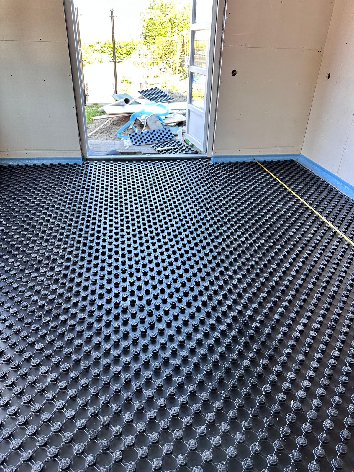 Noppenplaat met vloerverwarmingsleidingen in een aanbouw