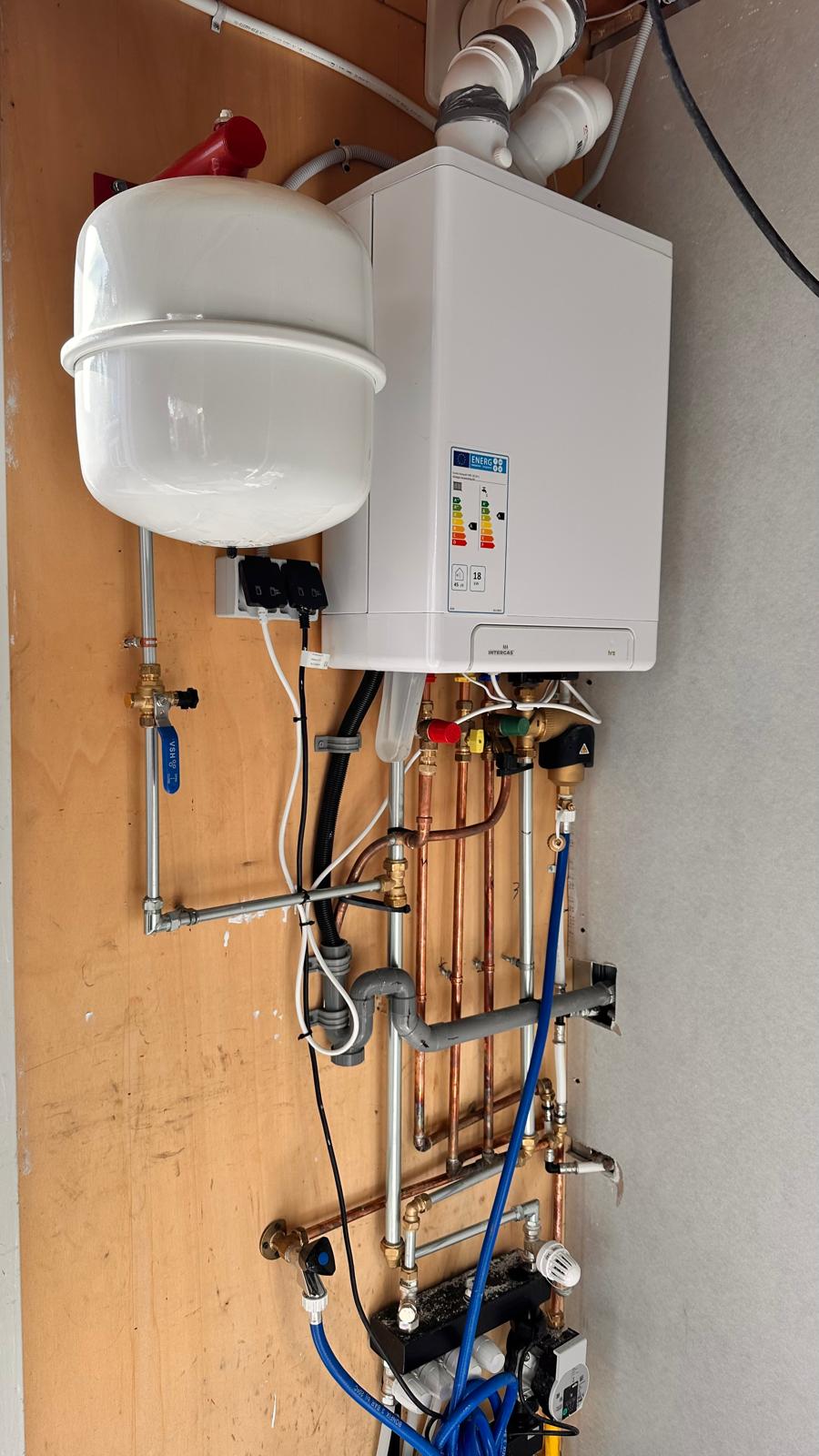Nette cv-ketelinstallatie met koperen leidingwerk en expansievat