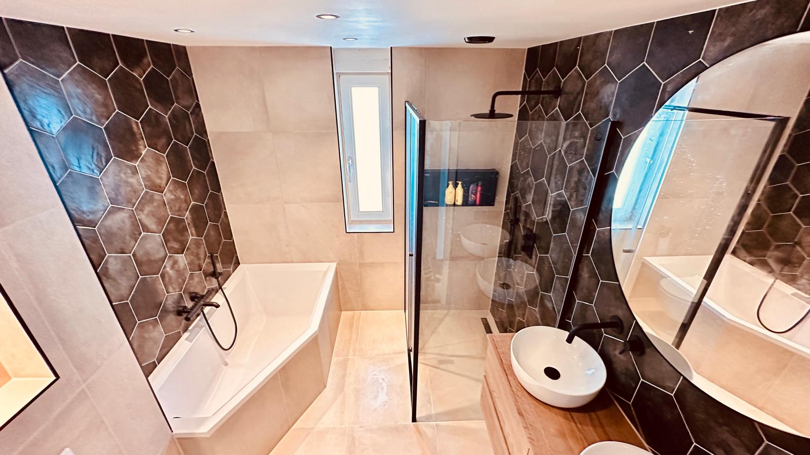 Moderne badkamer met hexagon tegels, inloopdouche en vrijstaand bad