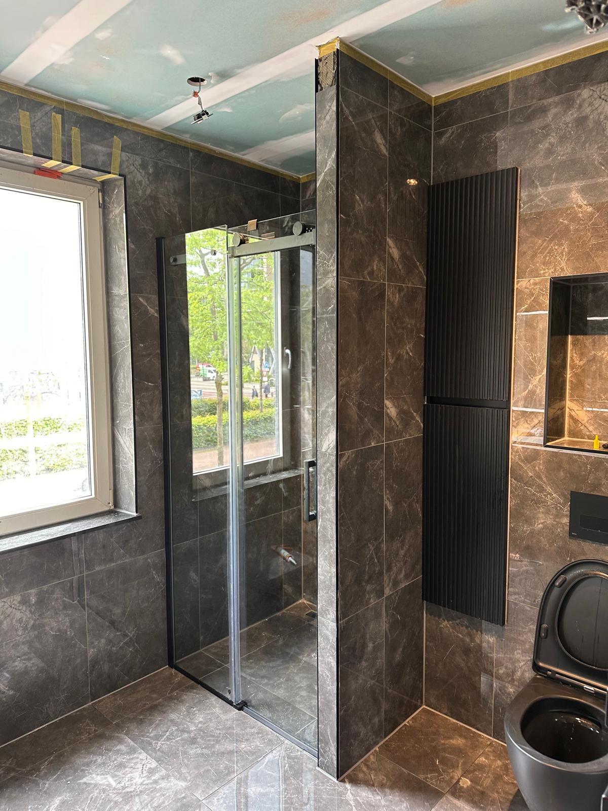 Badkamer met inloopdouche, marmerlook tegels en zwarte designradiator